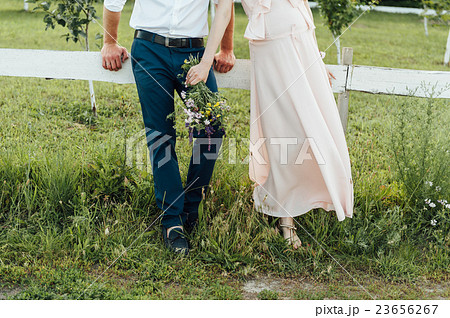 Pregnant woman holding wildflowers at the park 23656267