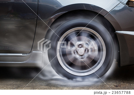 Car racing spinning wheel burns rubber on floor. Car racing spinning wheel burns rubber on floor. 23657788