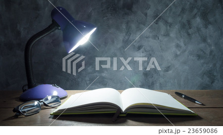 Lamp with notebook,pen and glasses on table  23659086