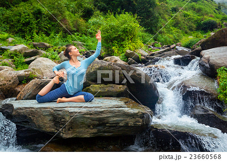 Sorty fit woman doing yoga asana outdoors at 23660568