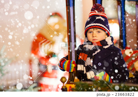 Little kid boy on carousel at Christmas market 23663822