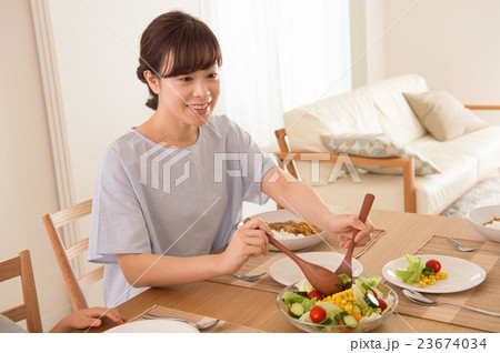 サラダを取り分ける女性の写真素材