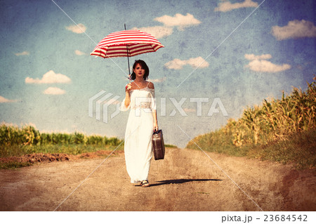 young woman with suitcase and umbrella young woman with suitcase and umbrella 23684542