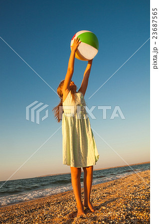 Adorable toddler girl playing ball on sand beach Adorable toddler girl playing ball on sand beach 23687565