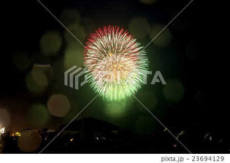 夏の柏崎市の海辺の雨の夜空を彩る幻想的な打ち上げ花火の写真素材