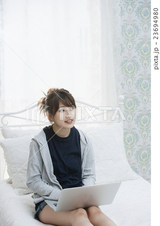 部屋着でPCを操作する若い女性 部屋着でPCを操作する若い女性 23694980