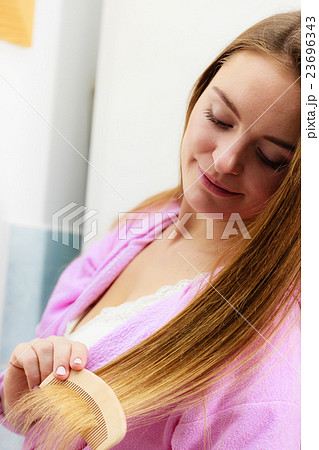 Woman combing her long hair in bathroom 23696343