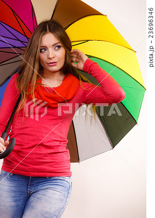 Woman standing under multicolored umbrella Woman standing under multicolored umbrella 23696346