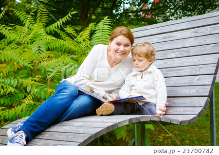 Little boy and his mother sitting on bench in park 23700782