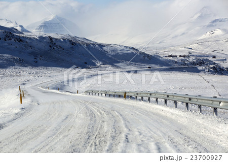 Snowy and icy road with volcanic mountains Snowy and icy road with volcanic mountains 23700927