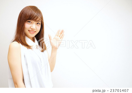 笑顔で指をさす若い女性 日本人 ポイント 指差し 女子 アピール セールスポイントの写真素材