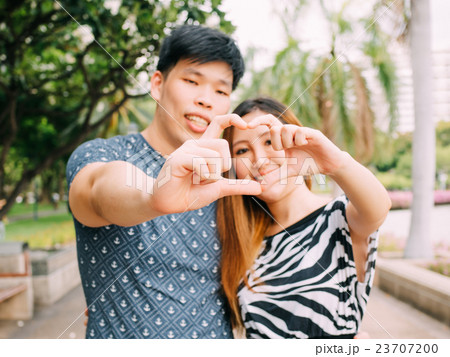 Closeup shot of young loving couple making heart Closeup shot of young loving couple making heart 23707200