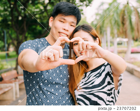 Closeup shot of young loving couple making heart Closeup shot of young loving couple making heart 23707202