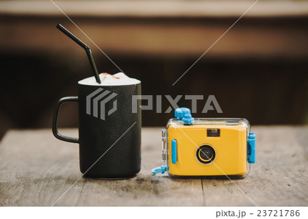 camera with coffee in cafe on wood table 23721786