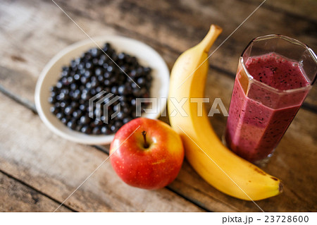 Glass of fresh smoothie with ingredients around 23728600