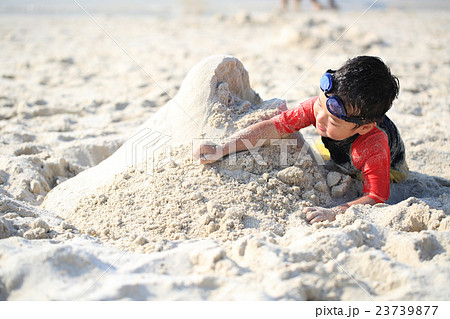 ビーチで砂遊びする子どもの写真素材