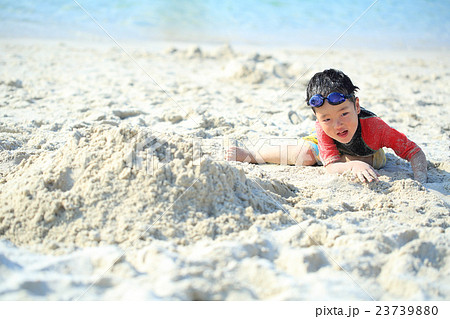 ビーチで砂遊びする子どもの写真素材