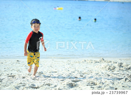 ビーチを笑顔で走る子ども 23739967