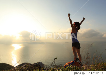 cheeringwoman backpacker at sunrise seaside  23740434