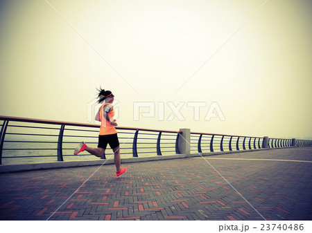 one  asian woman runner running on seaside 23740486