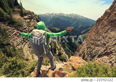 cheering backpacker open arms on mountain peak 23742122