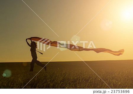 Young woman running on a rural road at sunset in 23753696