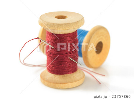 spool of thread and needle on white 23757866