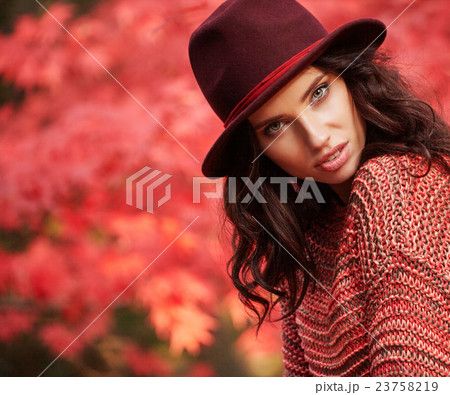 Beautiful woman standing in a park in autumn Beautiful woman standing in a park in autumn 23758219