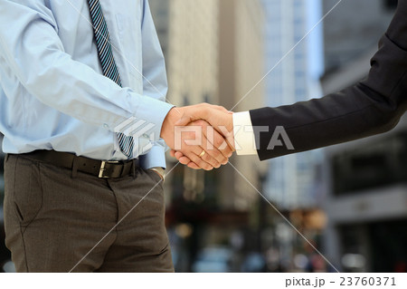 Firm handshake  between two colleagues outside 23760371