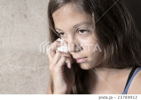 Sad and lonely girl beside wall 23769912