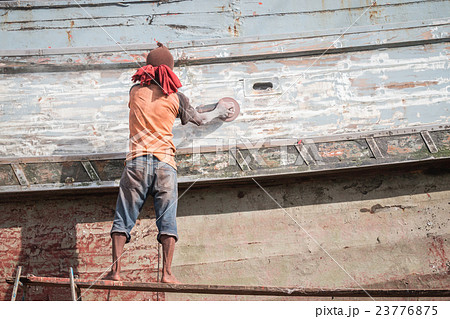 A man using grinder in preparation for anti foul paint being applied 23776875