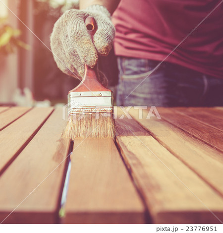Paintbrush in hand and painting on the wooden table. Retro and vintage style Paintbrush in hand and painting on the wooden table. Retro and vintage style 23776951