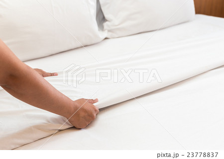Hand set up white bed sheet in hotel room 23778837