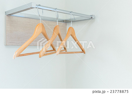 Wooden cloth hangers on the wall in hotel room 23778875