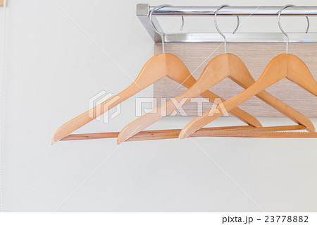 Wooden cloth hangers on the wall in hotel room 23778882