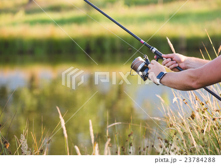 Man holding a fishing-rod. 23784288