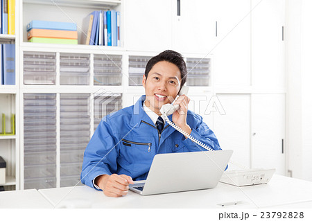 電話応対する作業服の男性 23792828