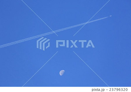 飛行機雲を引く飛行機と昼間の月 23796320