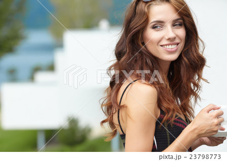 Woman drinking coffee in hotel terrace over sea Woman drinking coffee in hotel terrace over sea 23798773