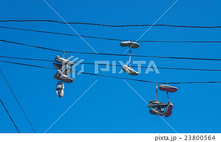 Shoes hanging on wires 23800564