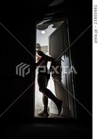 Man enters opening door from black room Man enters opening door from black room 23800981