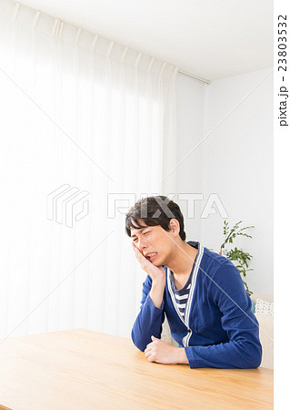 歯の痛み　歯痛　むしば　男性　ポートレート　男の人　リビング　コピースペース 23803532