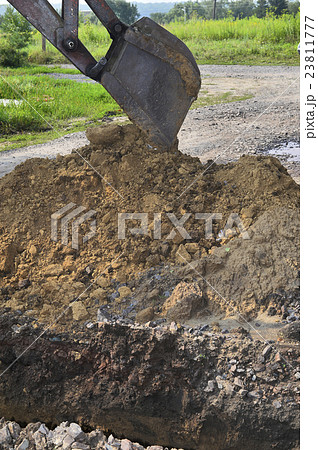 Excavator bucket digging a trench in the ground Excavator bucket digging a trench in the ground 23811777