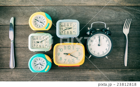 Time to eat concept. Clocks,spoon and folk on wood Time to eat concept. Clocks,spoon and folk on wood 23812818