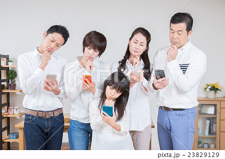 スマートフォンを見ながら首を傾げる3世代家族 スマートフォンを見ながら首を傾げる3世代家族 23829129
