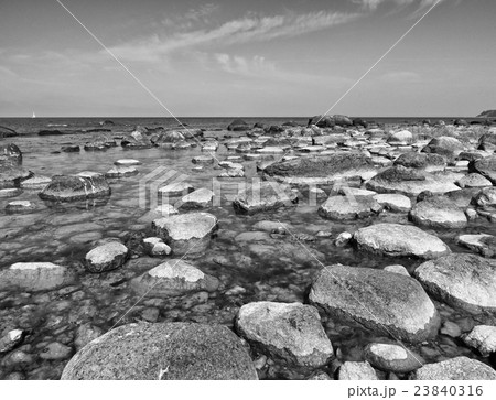 Big boulders in shore in smooth wavy sea. Big boulders in shore in smooth wavy sea. 23840316
