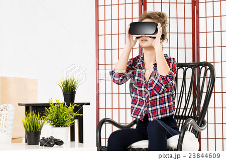 Girl getting experience using VR glasses of 23844609