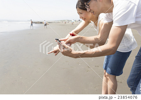 ポケモンGO イメージ カップル 海水浴場 真剣な表情 江ノ島 風 ポケモンGO イメージ カップル 海水浴場 真剣な表情 江ノ島 風 23854076