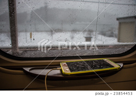 Rain drops on train window, Smartphone is charging Rain drops on train window, Smartphone is charging 23854453