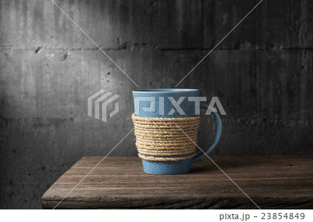 Rope wrapped around coffee cup on wooden desk Rope wrapped around coffee cup on wooden desk 23854849